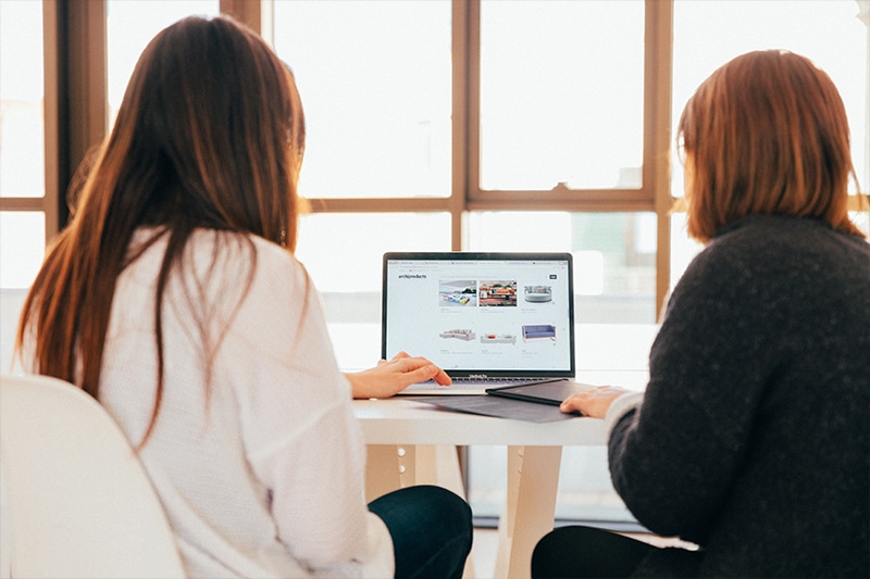 2 girls working at laptop