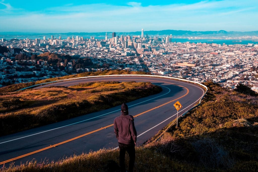 Man overlooking a road with a view of a skyline