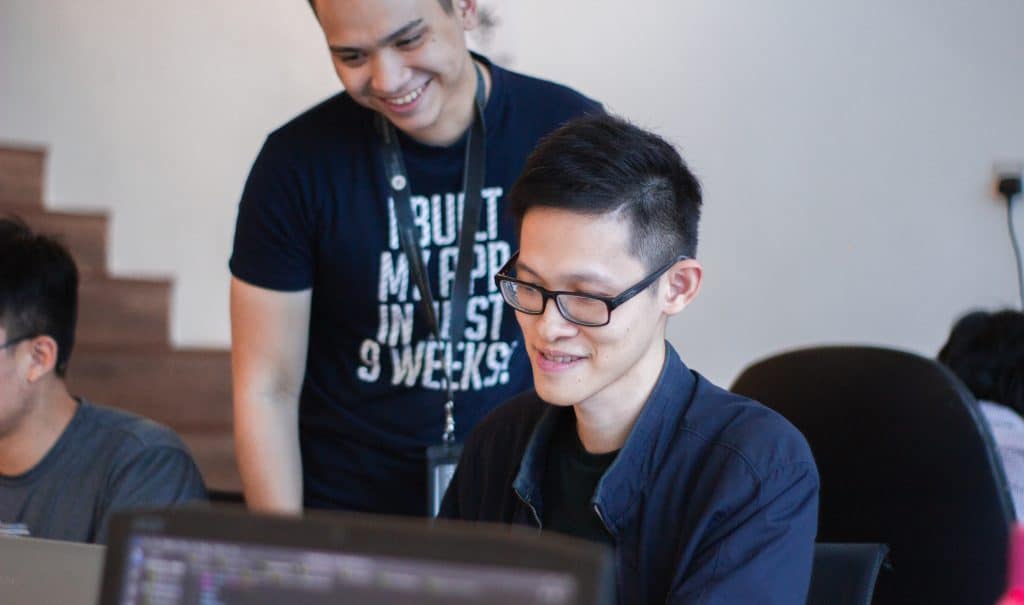 Professor giving advice to a student at a computer