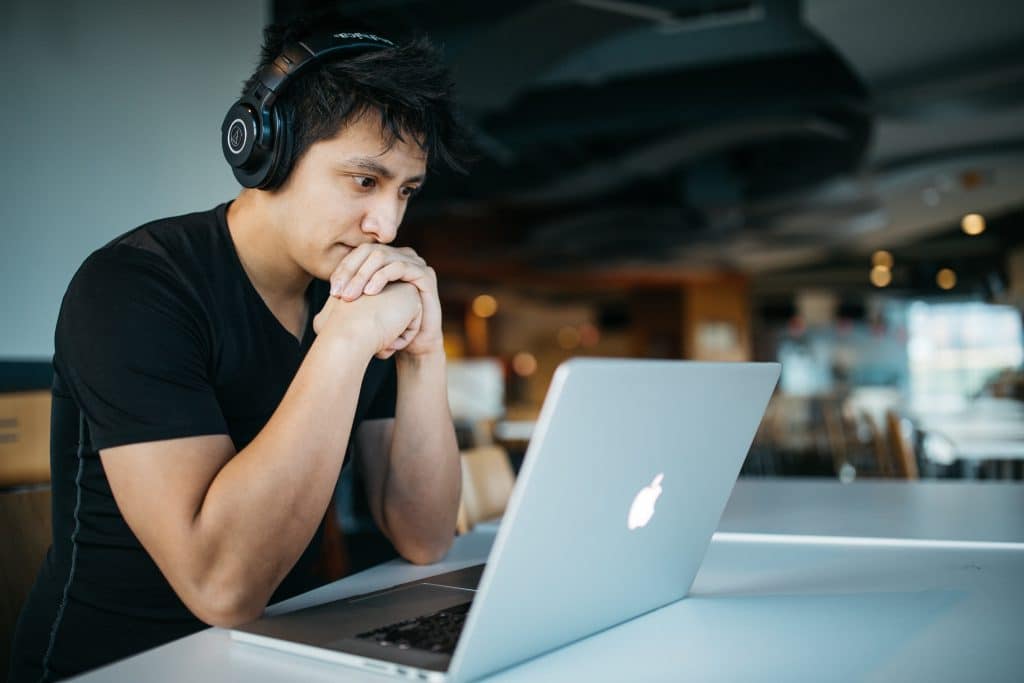 Man wearing headphones looking at his laptop